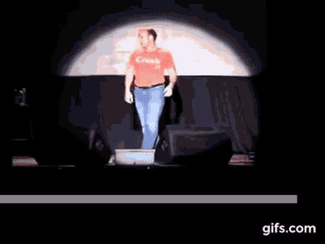 a man in a red canada shirt stands on a stage