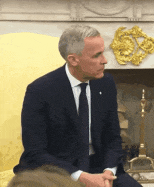 a man in a suit and tie sits on a yellow chair