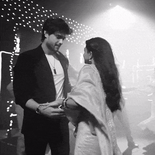 a black and white photo of a man and woman dancing in a dark room