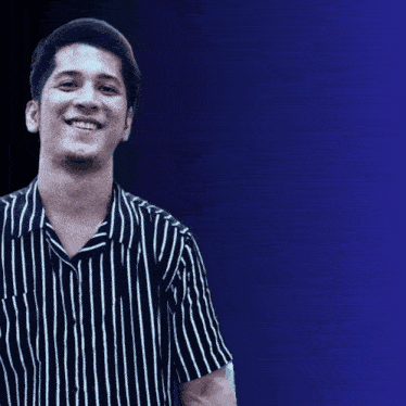 a man in a black and white striped shirt is smiling in front of a sign that says meski foto google