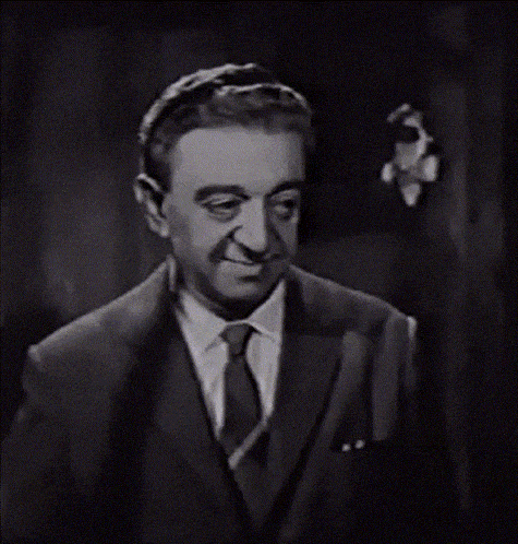 a man in a suit and tie is looking at the camera