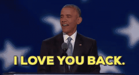 a man in a suit and tie is giving a speech and says i love you back .