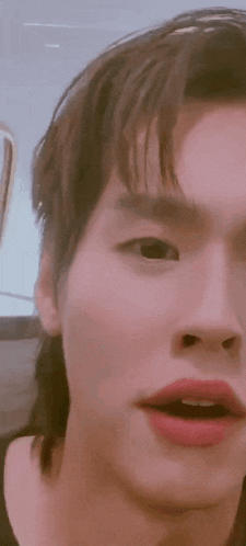 a close up of a person 's face with a mullet and red lipstick .
