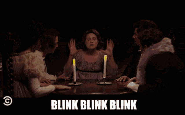 a group of people sitting around a table with the words blink blink blink
