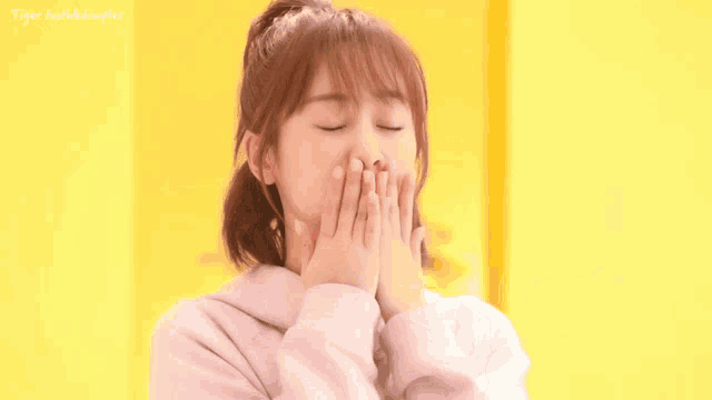 a girl is covering her mouth with her hands and the words tiger toothed dimples are visible in the corner