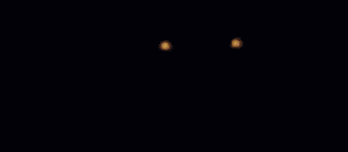 a close up of a statue with glowing eyes and a purple background