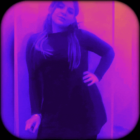 a woman in a black dress is standing in front of a purple wall
