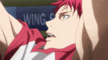 a man with red hair is standing in front of a sign that says " wing "