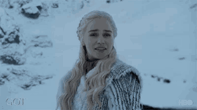 a woman is standing in the snow with the word got on the bottom