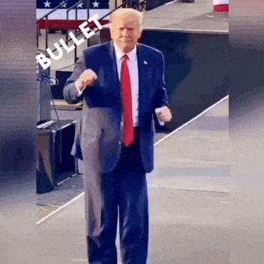 a man in a suit and tie is standing on a stage with the word bullet written on it