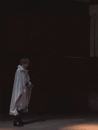 a person in a white coat is holding a purple light