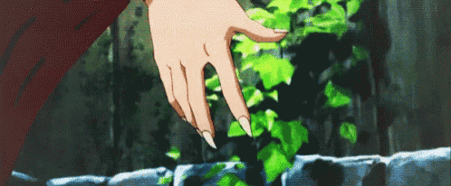 a close up of a person 's hand touching a plant with long nails .
