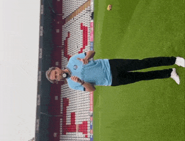 a man holding a microphone in front of a stadium that has the word willow on it