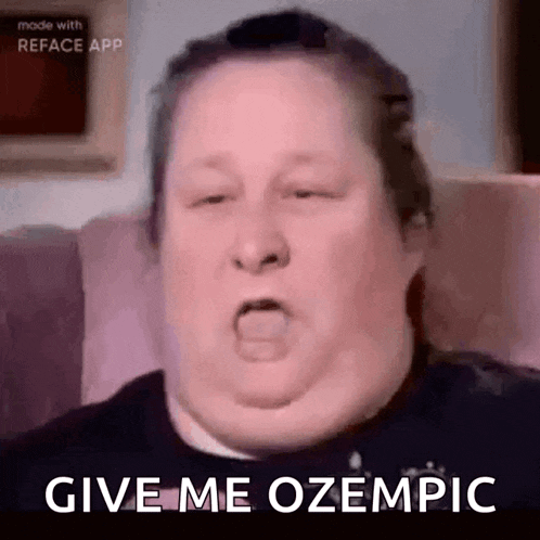 a fat man is sitting on a couch making a funny face and says `` give me ozempic '' .