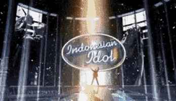 a man is standing in front of a sign that says indonesian idol