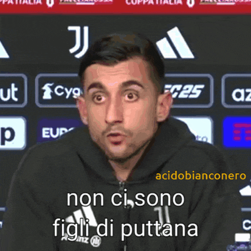 a man wearing a black hoodie with the word figli di puttana on it