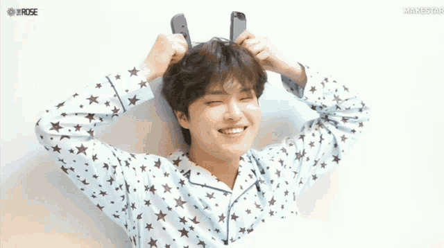 a young man wearing a pajama top with stars and bunny ears