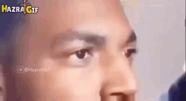 a close up of a man 's face with the words hazrat gif written on the bottom .