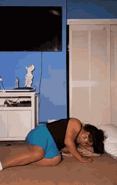 a woman laying on the floor in front of a television