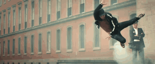 a man is doing a trick in front of a large building