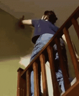 a person is standing on a wooden railing on a staircase .