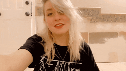 a woman wearing a black t-shirt that says " tam " on it
