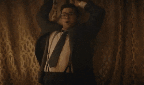 a man in a suit and tie is laying on a couch