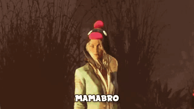 a woman in a suit and hat is standing in front of a bush .