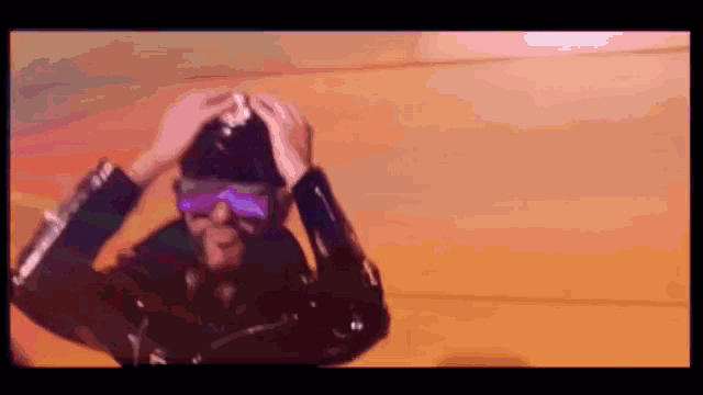 a man wearing a black leather jacket and purple sunglasses