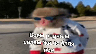 a blurry picture of a person wearing sunglasses and a sweater with russian writing on it .