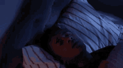a man is laying in bed with his eyes closed and a bandage on his eye .