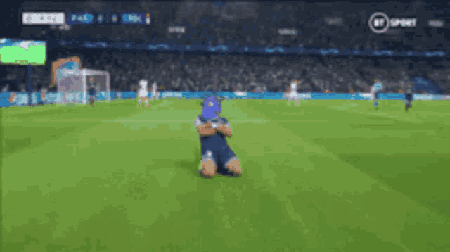 a soccer player is kneeling on the field with a bt sport logo in the background