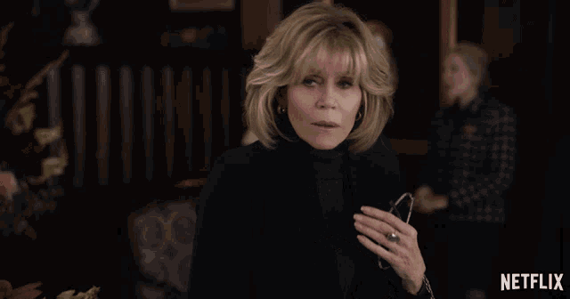 a woman with a ring on her finger stands in front of a netflix ad