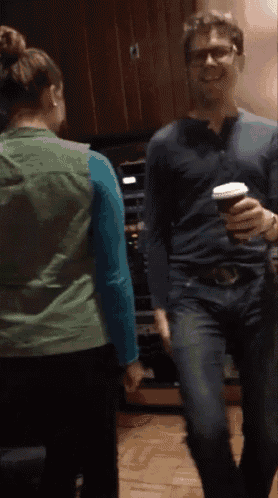 a man in a blue shirt holding a cup of coffee