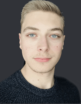 a young man with blonde hair and blue eyes is wearing a sweater