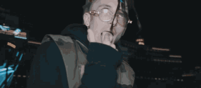 a man giving the middle finger in front of a sign that says ' i don 't stop '