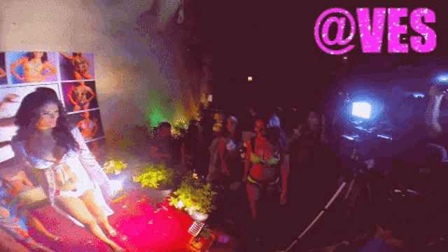 a woman is dancing in front of a sign that says @ves on it