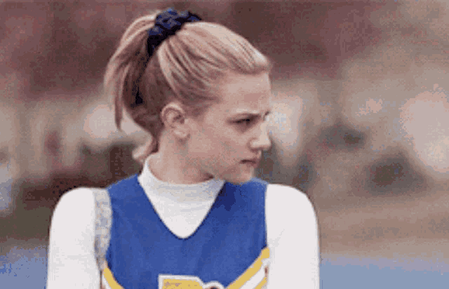 a cheerleader wearing a blue and yellow uniform with the letter d on the front