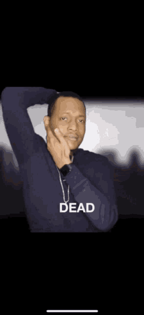 a man wearing a necklace with the word dead written on it