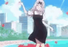 a girl in a black dress is dancing near a pool .