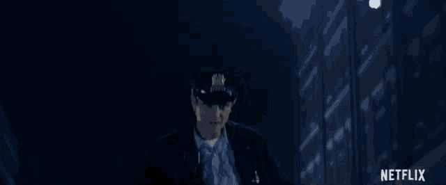a man in a police uniform is sitting in a dark room with a netflix logo in the corner .