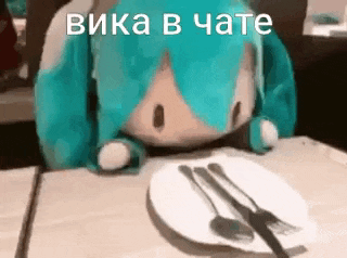 a stuffed animal is sitting at a table with a plate of food .