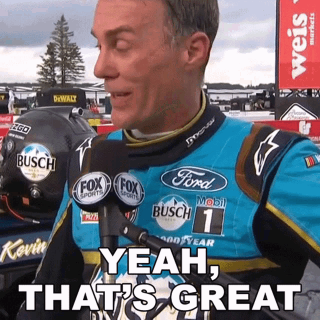 a man in a ford racing suit is talking into a microphone