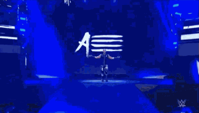 a wrestler named mustafa ali is standing in front of a blue background