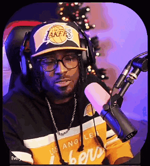 a man is wearing a lakers hat and headphones