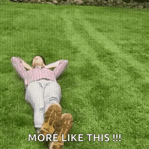 a man is laying on the grass with his feet up and the words `` more like this '' written next to him .