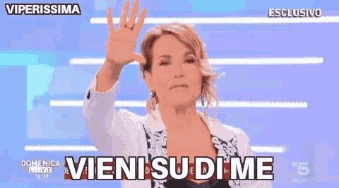 a woman in a white jacket is making a funny face and saying " vieni su dime "