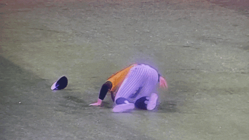 a baseball player is laying on the ground with his head down