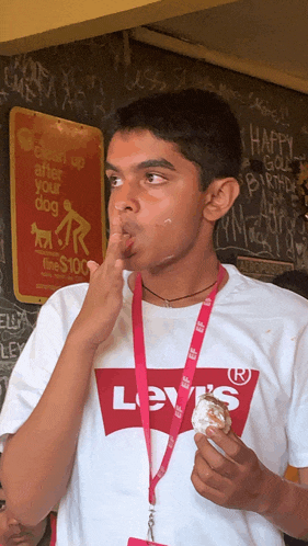 a boy wearing a levi 's shirt eating a donut