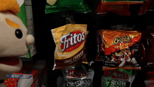 a bag of fritos chili cheese chips is next to a bag of cheetos